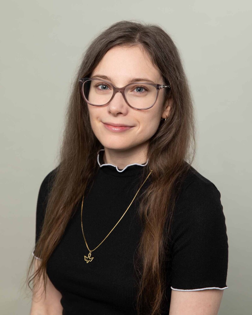 Gwendolyn Dussan, LPC Associate, wearing glasses and a black top, poses for a professional photo at Austin Therapy.