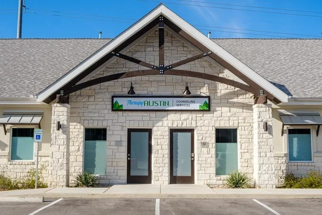 Exterior view of the Therapy Austin South Slaughter Location center entrance featuring stone architecture and unit 130