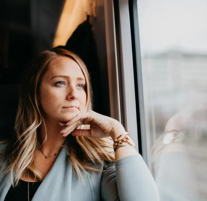thoughtful-woman-looking-through-train-window.webp
